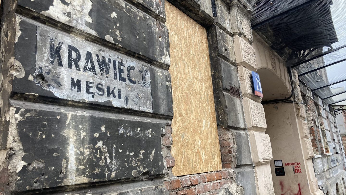 napis krawiec męski na budynku starej kamienicy