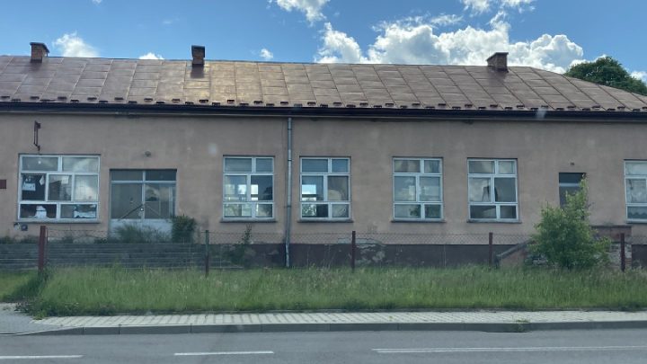 opustoszały budynek szkoły z wybitymi oknami